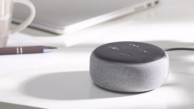 Amazon Echo Dot next to a Fire TV Stick remote showing Alexa integration